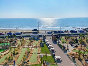 A coastal resort with a golf course, beach access, and a parking area.