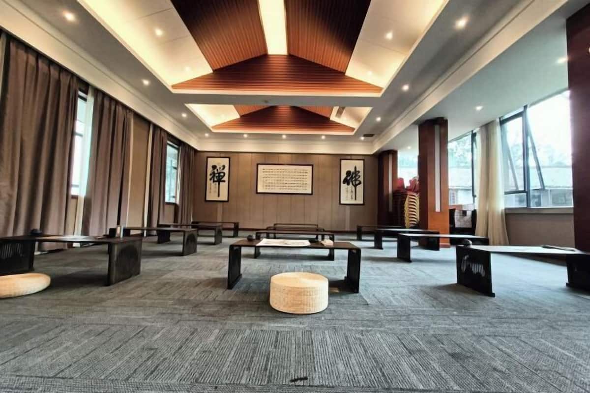 Une salle de conférence dotée d’un plafond haut, de lambris en bois et d’un sol recouvert de moquette.