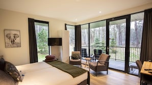 A modern bedroom with a large bed, a television, and a balcony with chairs and a table. - Boutique Hotel Bed & Bos (Best)