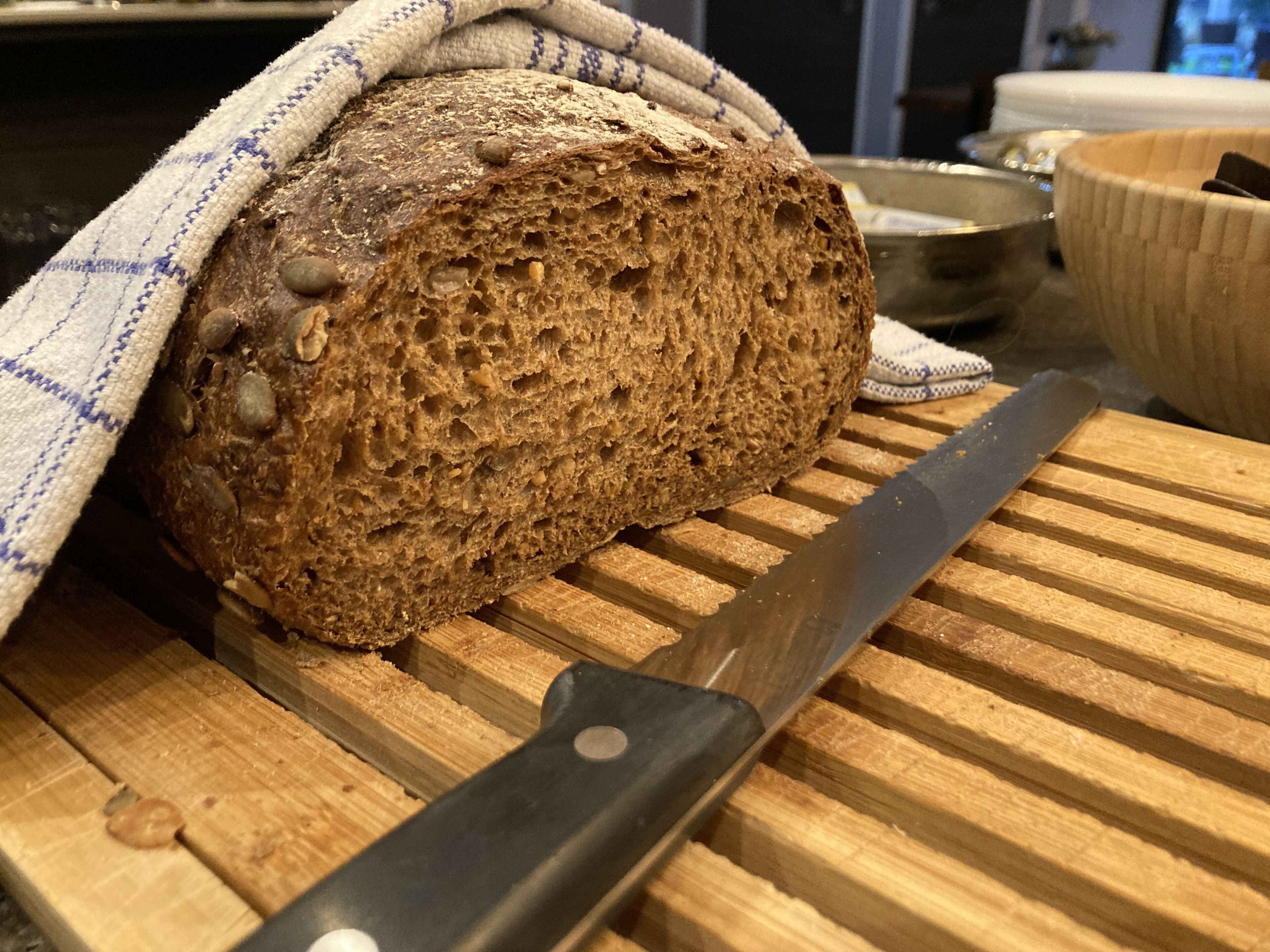 Brød på skærebræt med en kniv ved siden af.
