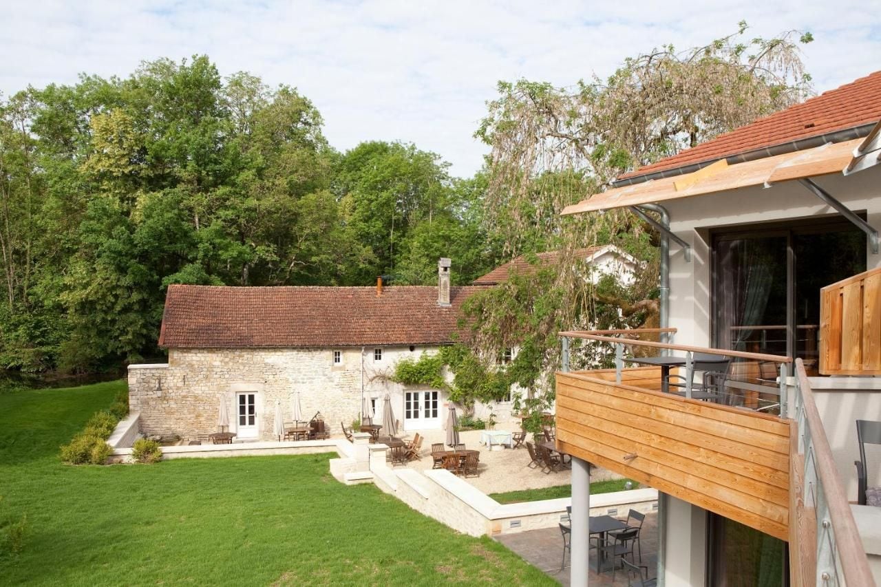 A stone house with a wooden deck and outdoor seating area.