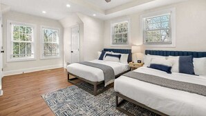 A bedroom with two beds, a ceiling fan, and large windows. - Beautifully Modern Cottage in Historic Norcross (Norcross)