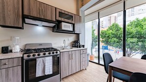 Eine moderne Küche mit Herd, Mikrowelle und Spüle. Ein Fenster bietet einen Blick nach draußen.