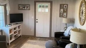 A living room with a television, sofa, and lamp. - Serenity Lakeside Cottage (Edinboro)