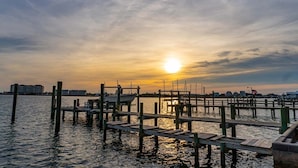 A wooden pier extending into calm water with a sunset in the background. - Speight House, Soundfront House in Historical Beaufort, NC! (Beaufort)