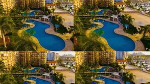 A hotel with a large swimming pool, multiple balconies, and a view of the surrounding area. - Condos PDS (Mazatlán)