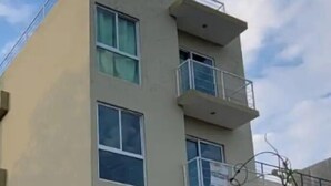 Un immeuble à plusieurs étages doté de balcons et de grandes fenêtres.