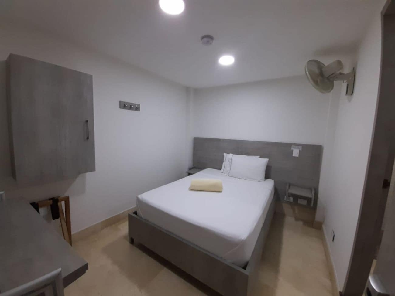 A bedroom with a bed, bedside table, and a wardrobe.