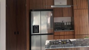 A kitchen with a stainless steel refrigerator, a built-in oven, and a gas stove. - CASAS PB (Mazatlán)