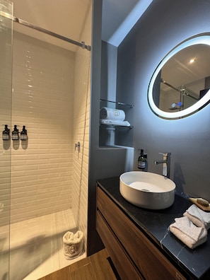 Een douche, een regendouche, gratis toiletartikelen, handdoeken