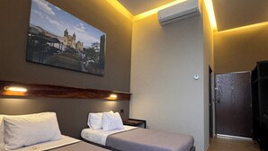 A hotel room with two beds, a painting on the wall, an air conditioning unit, and a wooden floor. - Amae21 Lofts (San Pedro Garza García)