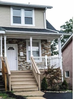 Stroll up the charming porch to a cozy home with a garden view.