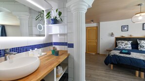 A modern bathroom with a white sink, blue-tiled backsplash, and a mirror with integrated lighting. - Santorini bed and breakfast with terrace and swimming pool (Montreuil)