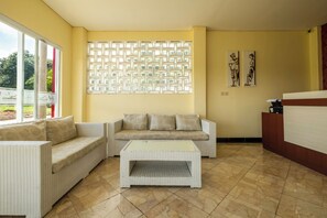 Quarto com sofá, mesa de centro e parede estampada.