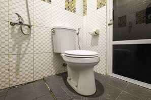 A bathroom with a toilet, shower, and tiled walls. - OYO 2947 Cluster Harris Home Stay and Kos (Cimahi)
