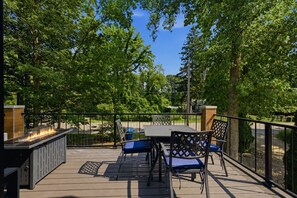 An outdoor patio with a grill, table, and chairs.