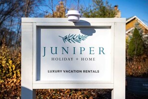 Letrero de Juniper Holiday + Home, alquileres vacacionales de lujo.