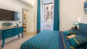 A bedroom with a bed, a dresser, a TV, and a window with curtains. - Solferino apartment near Roma Termini central station (Rome)