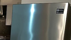 Un réfrigérateur en acier inoxydable doté d’un écran numérique et d’un distributeur d’eau.