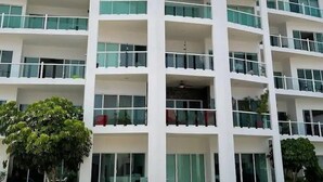 Un immeuble à plusieurs étages, doté de balcons, de grandes fenêtres et d’un toit plat.