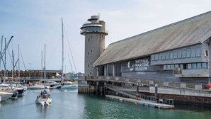 A marina with boats docked, a lighthouse, and the National Maritime Museum building. - Stylish Apartment in Falmouth, nr Seafront (Falmouth)