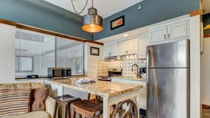 A modern kitchen with a central island, stainless steel appliances, and a bar stool seating area. - Lodge at Mtn Village A104 | Ski-In/Out | Valley View | PCMR | Pool | Hot Tub (Park City)