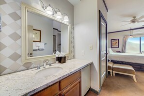 Une salle de bain avec un grand miroir, un lavabo et des meubles en bois.