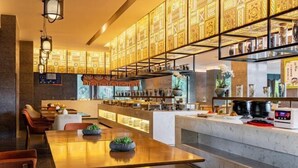 A modern restaurant with a long counter, seating area, and decorative wall panels. - Xianfeng Pingbaying Forest Hotel (Xianfeng)