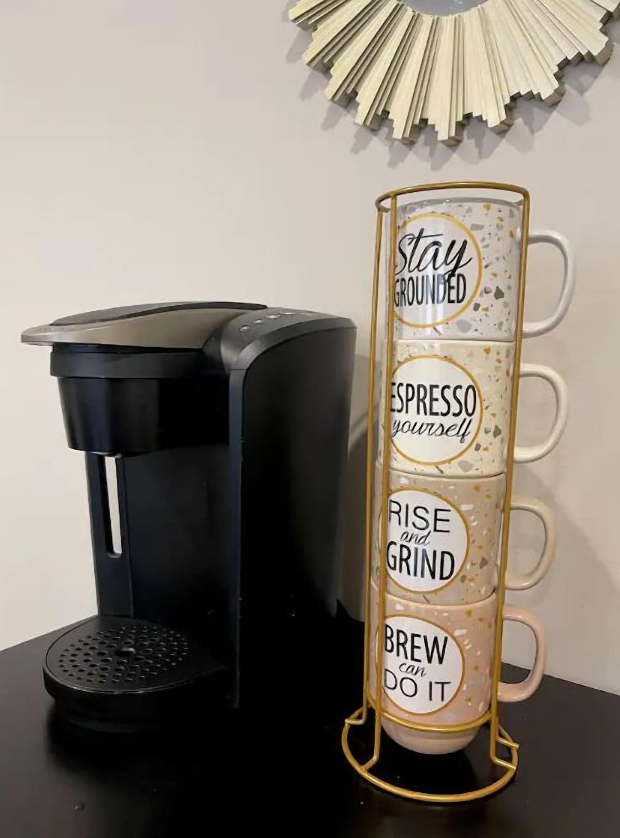 A coffee maker and a mug with motivational phrases.