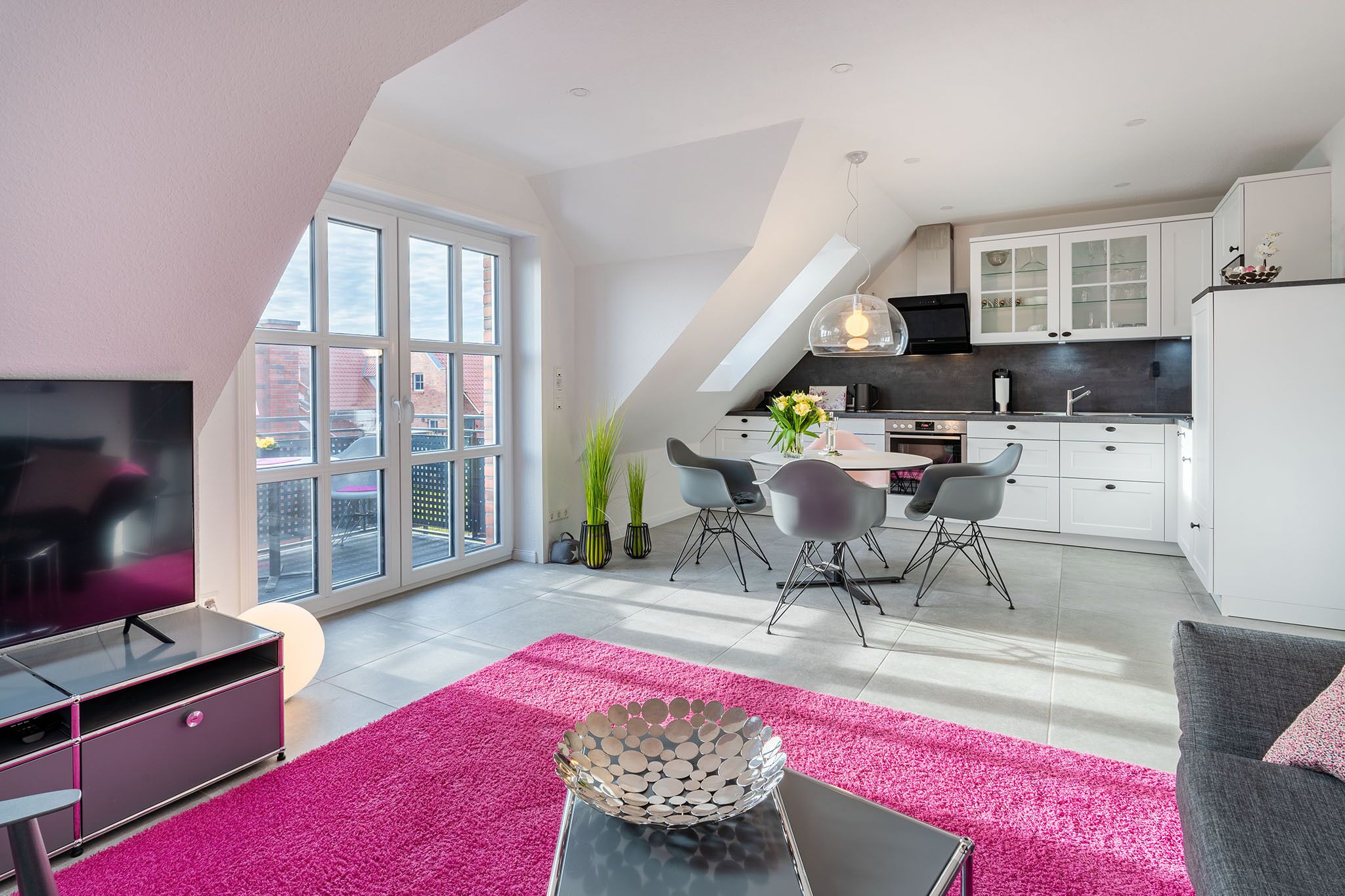 Ein modernes Apartment mit Essbereich, Küche und Wohnzimmer.