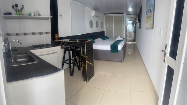 A compact hotel room with a kitchenette, a bed, and a bathroom. - Aloha Beach Sai (San Andrés)