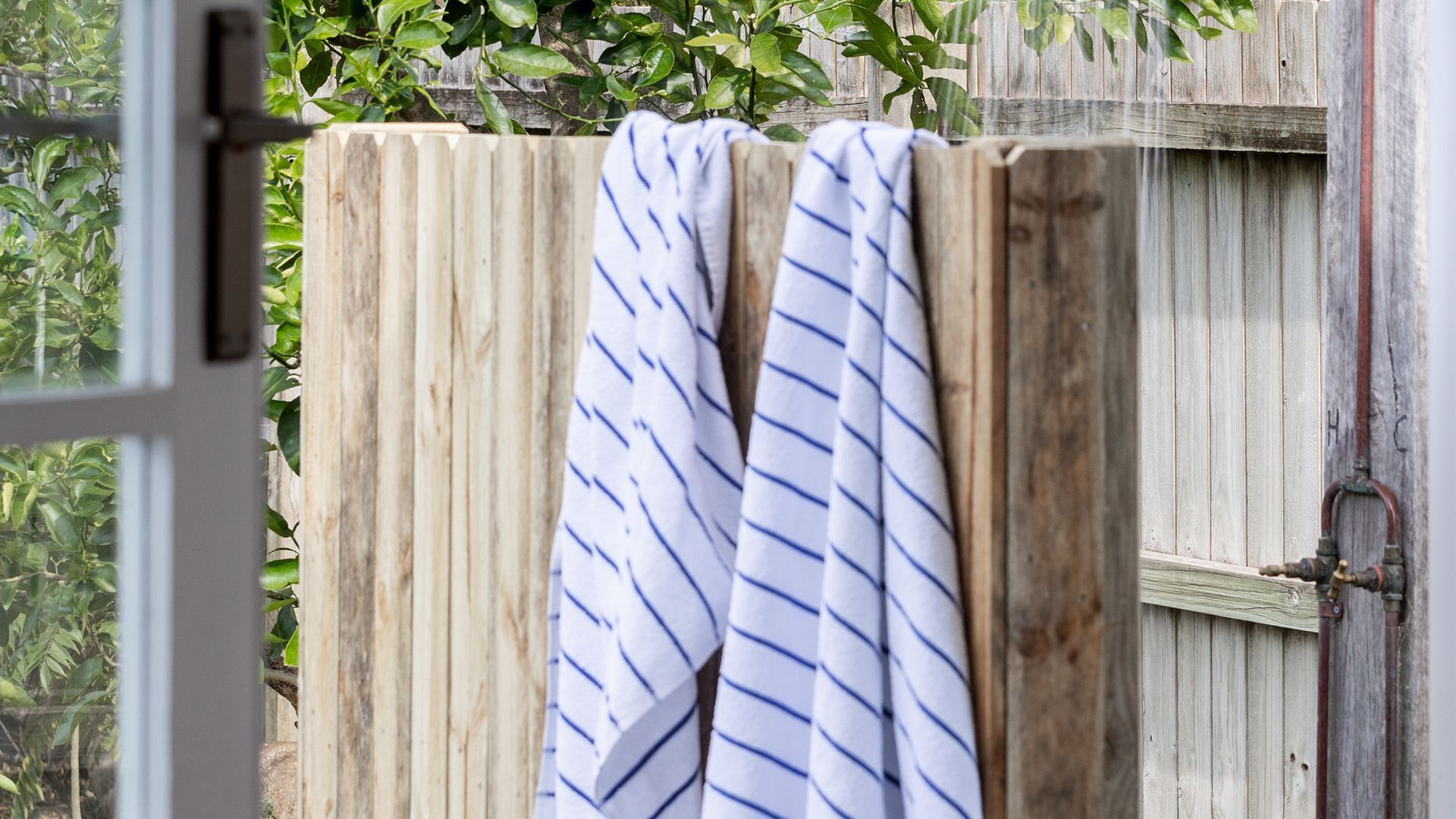 A wooden fence with a white towel hanging on it.