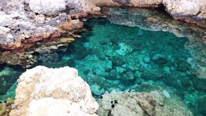 A natural rock formation with clear turquoise water. - Boffy Houses (Lecce)