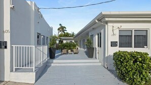 A narrow, white-walled corridor with a tiled floor, leading to a building with a door marked "605". - Beach Studio · 2 Min Walk to Hollywood Broadwalk (Hollywood)