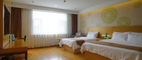 A hotel room with two beds, a wooden floor, a large window with curtains, and a wall with circular patterns.