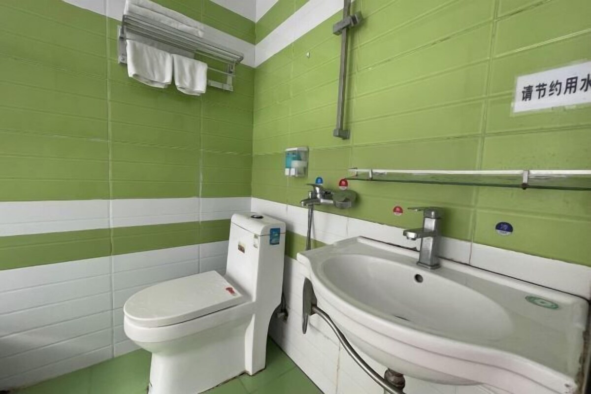 A small bathroom with a toilet, sink, and towel rack.