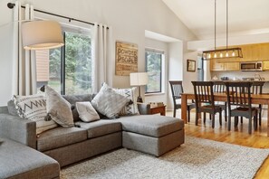 Relax in this stylish living space with a sofa, dining table, and modern kitchen.