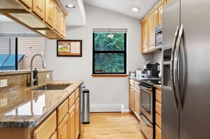 Enjoy cooking in this well-equipped kitchen with a large window offering a view of the surrounding greenery.