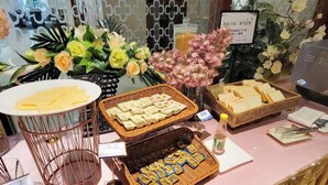 A buffet setup with various food items and decorative flowers. - Haili Apartment (Guangzhou)