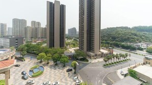 A residential complex with high-rise buildings, a central courtyard with a fountain, and a surrounding road. - Haili Apartment (Guangzhou)