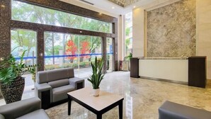 A modern lobby with a marble floor, a reception desk, and seating area with a chandelier. - Haili Apartment (Guangzhou)