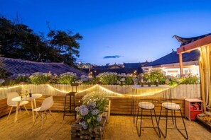 An outdoor patio area with seating and a view of a traditional building. - Yuhuai Renjia Inn (Lijiang)