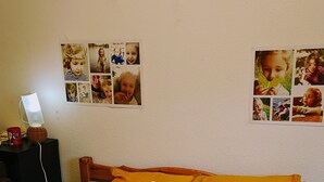 Un lit bien fait, agrémenté de plusieurs coussins et d’un ours en peluche.
