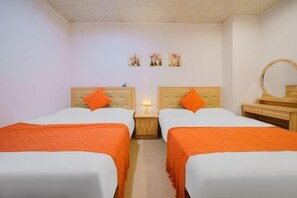 A hotel room with two beds, each with an orange bedspread and matching pillows. There is a nightstand with a lamp between the beds, and a wooden dresser with a mirror to the right. - Puning Shi Hai Apartment (Puning)