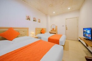 A hotel room with two beds, a television, and a door. - Puning Shi Hai Apartment (Puning)