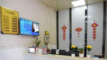 A reception area with a computer monitor, a telephone, and a reception desk.