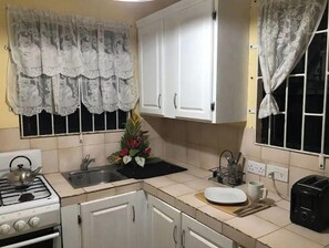 Kjøleskap, ovn, kjøkkenutstyr og spisebord