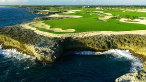 A coastal golf course with bunkers and a water body. - Unique Moroccan Style Villa in Golf Beach Resort (Punta Cana)