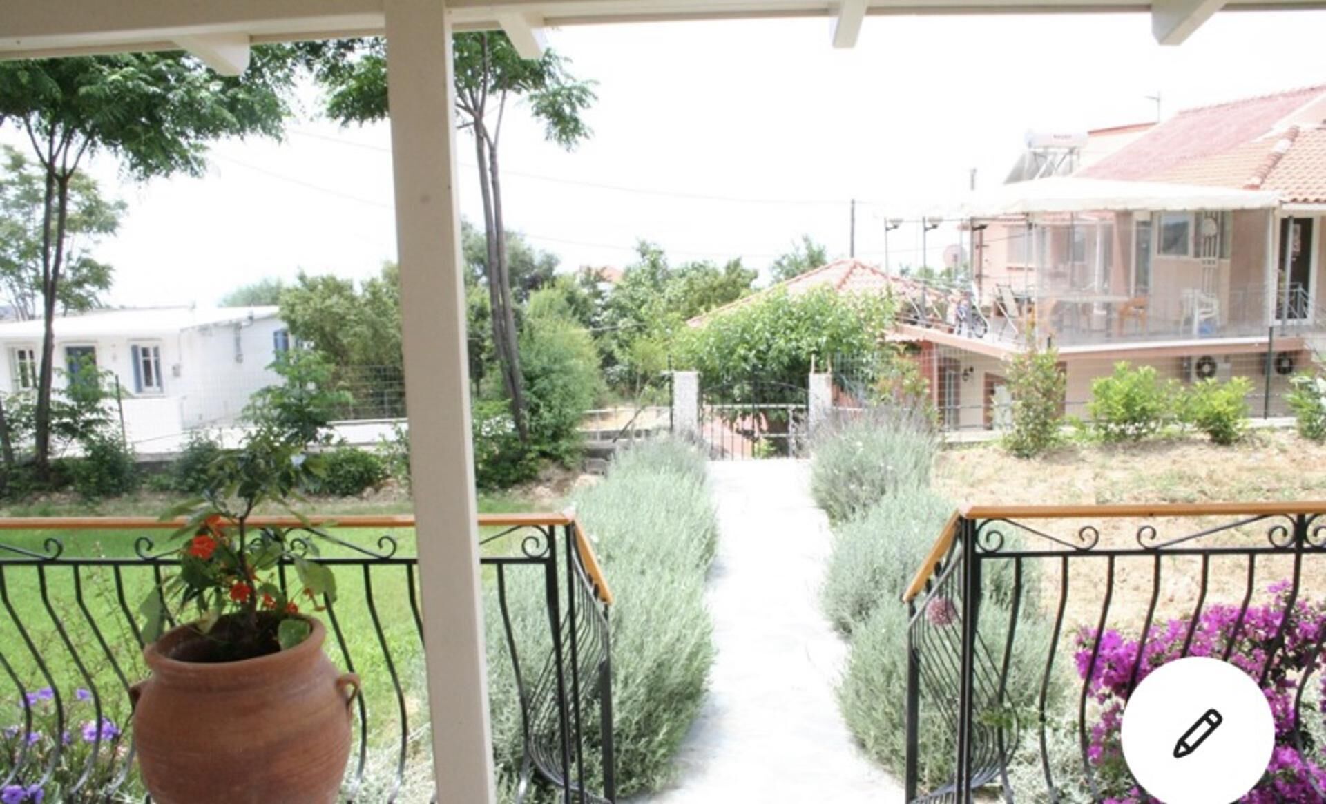 A balcony with a view of a garden and buildings.