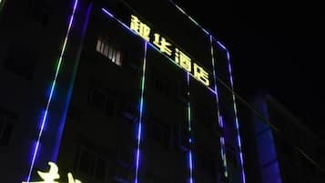 Un hotel con letreros iluminados y una entrada visible.